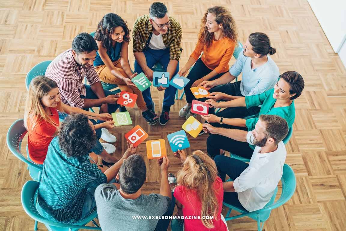 People sitting around a table with phones and social media platforms.